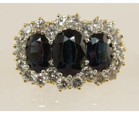 An 18ct substantial sapphire and diamond ring the central sapphire of approx 9.7mm x 6.8mm x 4.5mm is flanked by two sapphire