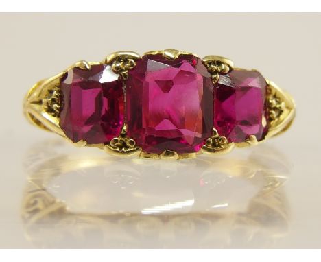 An 18ct gold three stone ruby ring in a Victorian style pierced galleried mount finger size N1/2