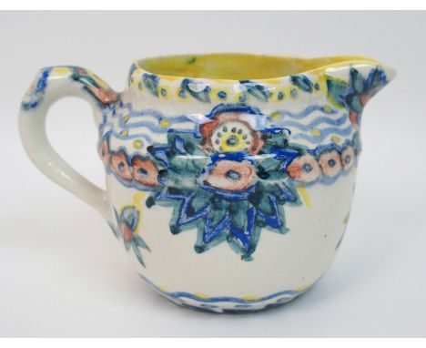 Jessie M King (1875-1949) A pottery jug hand painted with stylised floral decoration amongst wave and dot banded borders, in 