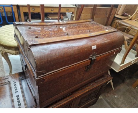 A metal travel trunk with simulated oak paintwork. 
