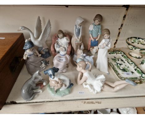 11 Nao figures including children, cats, dogs, geese