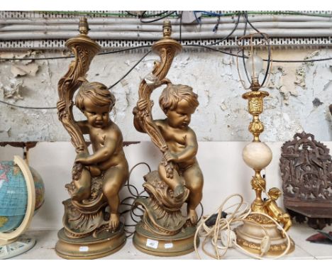 A pair of large lamp bases in the form of gilt cherubs and another lamp with gilt column and cherub 