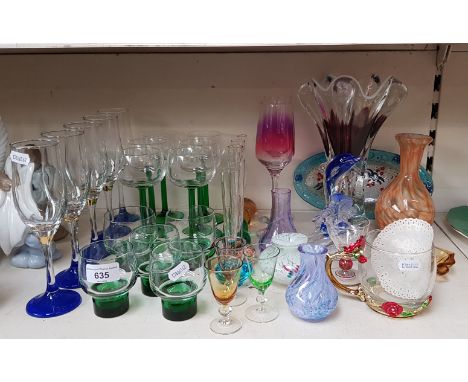 A selection of coloured stemmed or based glassware including drinking glasses, posy glasses, large pulled glass vase, includi