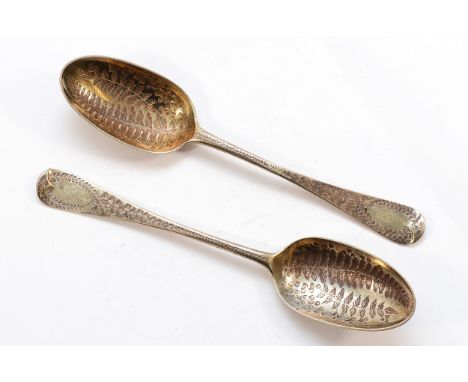 Two silver serving spoons having bright cut botanical engraving to the bowl and handle, London, date letter worn, one made by