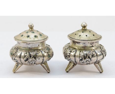 A pair of Chinese silver incense burners, embossed with oriental flowers, raised on three tripod feet, 5cm, 102gm