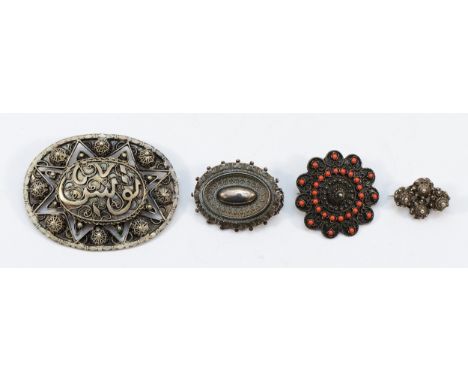A 935 silver and coral circular brooch, 35mm, a silver oval brooch, 40mm, an unmarked silver brooch with Islamic text, 65mm, 