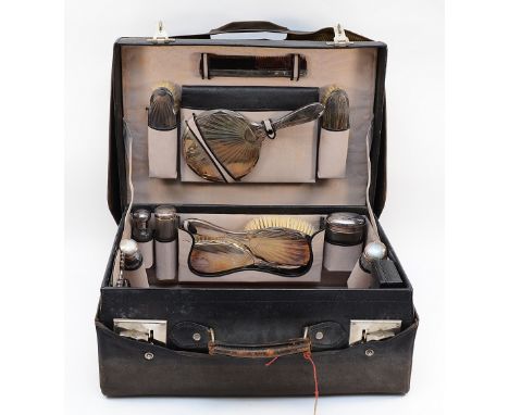 An Art Deco silver mounted travelling dressing set, Birmingham 1926/7, comprising, hand mirror, two hair brushes, two clothes