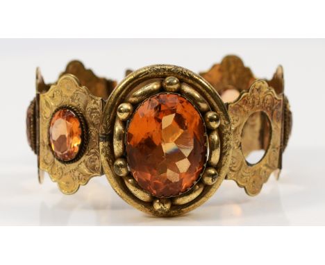 A Victorian pinchbeck and citrine paste panel link bracelet, with engraved decoration, 16cm, lacking two stones
