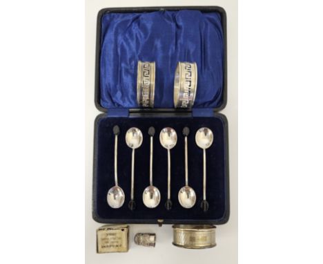 A set of six silver coffee spoons, Chester 1921, cased, together with three silver napkin rings, Birmingham 1928, 1928, 1948,