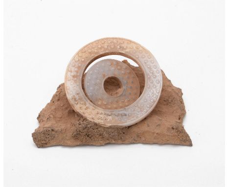 Two Chinese archaic-style white jade disks, both carved in low relief with a dense pattern of raised bumps, attached to a sto