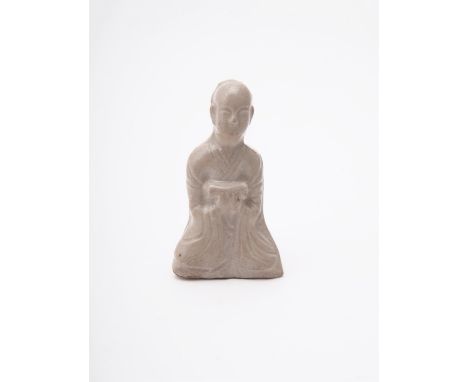 A Chinese press-moulded figure of a seated scholar, Song Dynasty, with white-grey-green glaze, with both arms central and hol