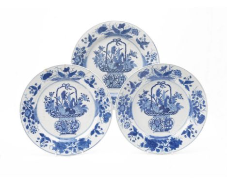 Three Chinese blue and white plates, Kangxi, each painted with baskets of fruit and flowers, 28.5cm diameter (3)Provenance: T