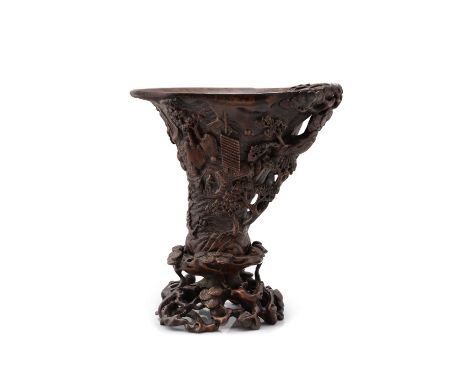 A Chinese wood carved libation cup and stand, possibly aloeswood, carved in high relief as a segment of a pine tree trunk, de