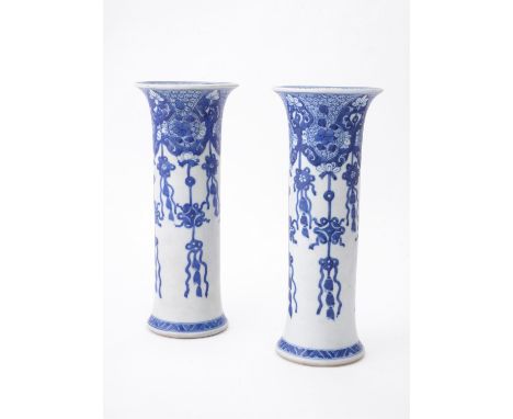 A pair of Chinese 'Shipwreck' blue and white trumpet vases, Kangxi, painted with pendant ribbons and brocade balls, 25.5cm hi