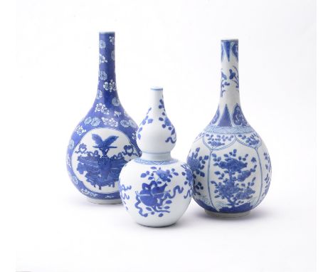 Three Chinese blue and white 'Shipwreck' bottle vases, Kangxi, variously painted with panels of flowers and precious objects,