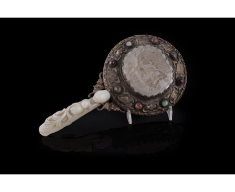 A Chinese silver plated mirror mounted with jade, the jade 18th/19th century, the silver oval hand-mirror decorated in relief