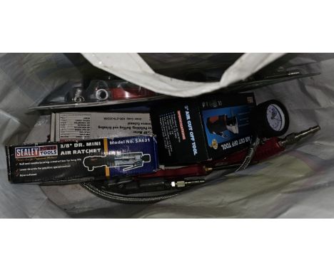A bag of air tools, many unused. 