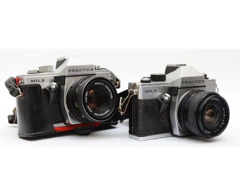 A collection of cameras and lenses to include the following: a Praktica MTL 3 35mm film camera with a Pentacon 50mm f1.8 lens