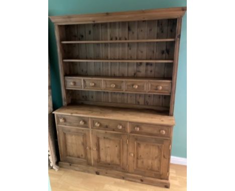 A modern pine kitchen dresser, the upper section having plate rack with spice drawers above three drawers, and three panelled