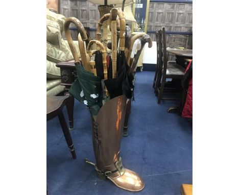 COPPER STICK STAND IN THE FORM OF A BOOT, full of walking sticks and umbrellas including one example with a gold ferrule