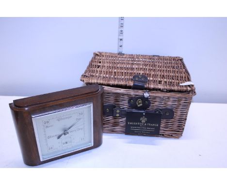 A small wicker basket and a vintage oak cased barometer 