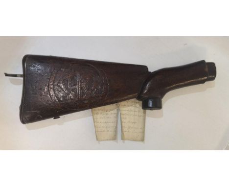 A stock of a British rifle captured in the First Boer war having a carve motif together with a hand written note that reads '