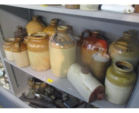 A selection of mainly stoneware flagons, some advertising examples to include Harrods Stores Ltd Grocery Department, Thomas G