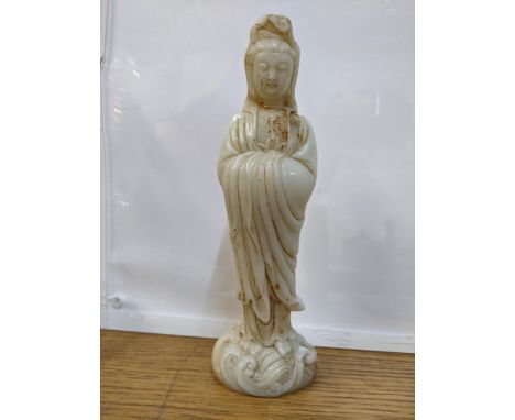 A Chinese off white jade coloured statue of a woman on a wave design base 24cm high 