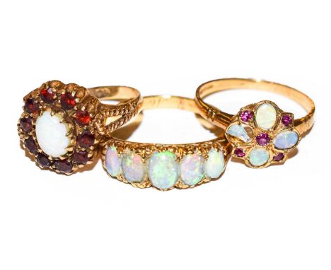 An opal five stone ring, stamped ‘18’, finger size Q; a 9 carat gold opal and garnet cluster ring, finger size N; and a 9 car