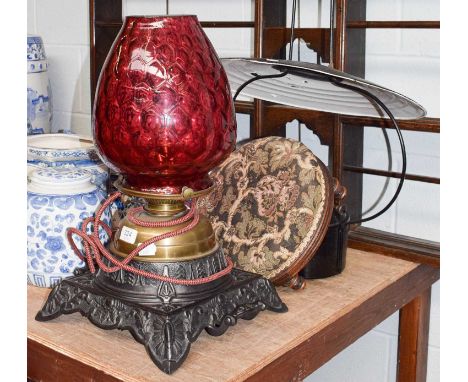 A Victorian brass oil lamp on a cast metal base with Ruby glass shade, together with a hanging oil lantern and a foot stool
