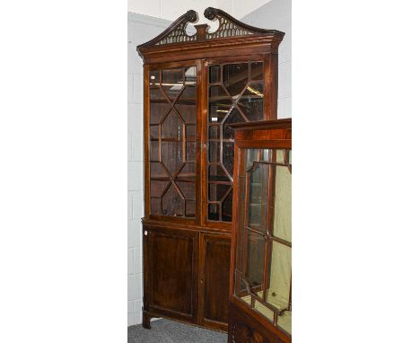 A George III mahogany astragal glazed standing corner cupboard in the Chippendale taste, with pierced broken swan neck pedime