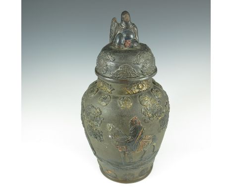 JAPANESE TERRACOTTA POT AND COVER, APPLIED DECORATION DEPICTING FIGURES, TREES AND MEDALLIONS, SEATED FIGURE FINIAL TO THE CO