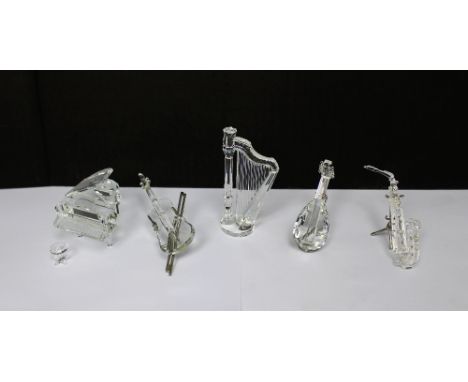 A collection of boxed Swarovski crystal musical instruments to include harp, grand piano and stool, lute, saxophone and violi