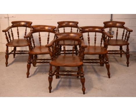 A set of five elm seated smokers' bow-back elbow chairs, labeled for 'Kirk and Townsend, Cabinetmakers and Carpet Warehouseme