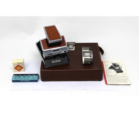 A Polaroid FX-70 folding Land camera with chrome body and brown covering, in a fitted case with instructions, boxed lens shad