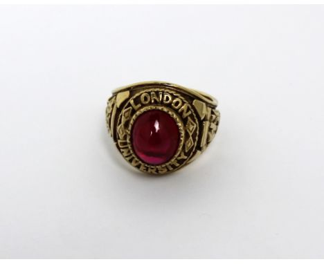 A 9ct gold gentlemen's dress ring inscribed 'London University' with coat of arms to shoulders and a central cabochon ruby, s