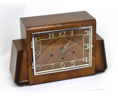 An early 20th century walnut-veneered Art Deco mantel clock, the dial set with Roman numerals.