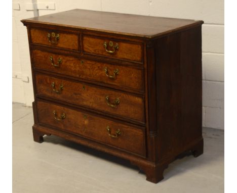 An early 19th century oak and mahogany cross-banded chest of two short and three long drawers on bracket feet, width 112cm. C