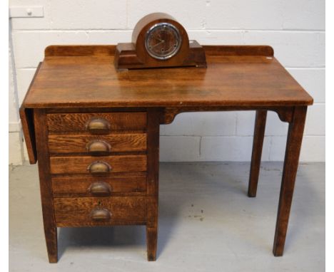 A mid-20th century oak kneehole desk with five drawers and single drop-leaf to left-hand side, on tapering supports, width wh