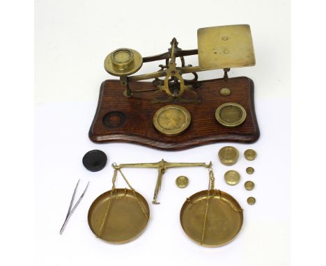 A set of oak and brass postal scales and weights and a set of modern scales.