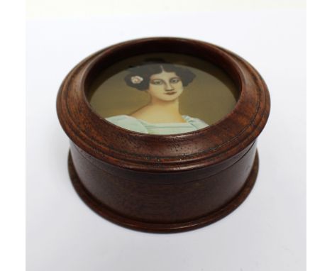 A lidded treen trinket box, the lid set with glazed painted miniature of a brunette, fair-skinned lady, diameter 8.5cm.