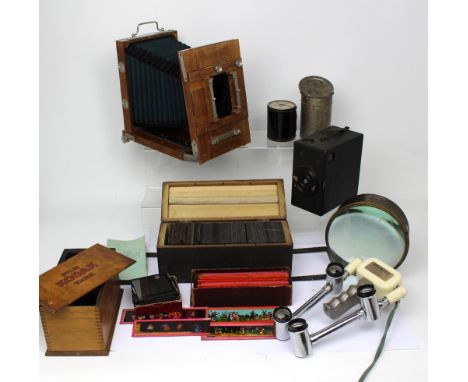 A collection of photographic equipment to include a Kodak film tank, a Boxed Brownie, a Mobilite exposure, two boxes of glass