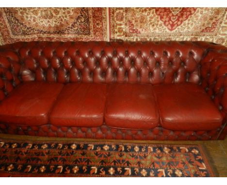A Chesterfield style red leather four seater button back sofa.