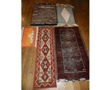 A collection of rugs to include an Afghan blue and red runner, a Kilim prayer rug and three other. 