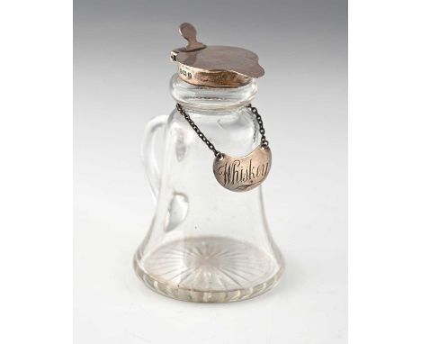 A George V silver mounted glass whisky noggin, of flared conical form, the glass body with loop handle and star cut base, the