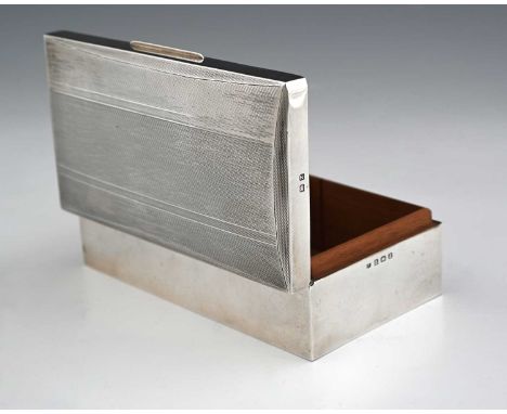 A George VI silver cigarette box, of rectangular form, the hinged cover with canted sides, decorated with engine turning, the