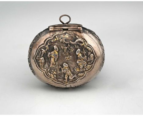 A silver-coloured metal spice box, of oval form, with a hinged cover, decorated in relief with traditional figures, the under
