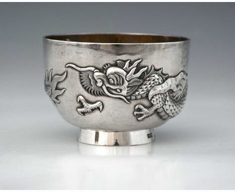 A late nineteenth or early twentieth-century Chinese export silver bowl, decorated in high relief with a repoussé dragon moti