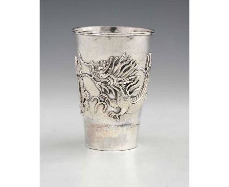A Chinese silver-coloured metal beaker, of tapered cylindrical form, the exterior decorated in relief with a dragon, and vaca