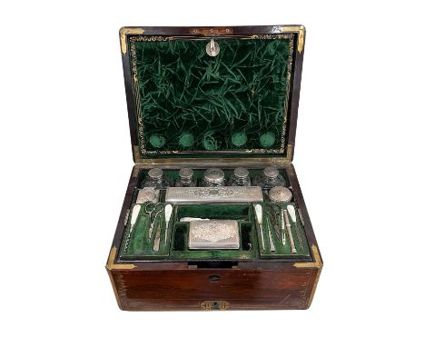 An early Victorian rosewood and brass bound dressing case, the brass lift-out carrying handles to either side, brass escutche